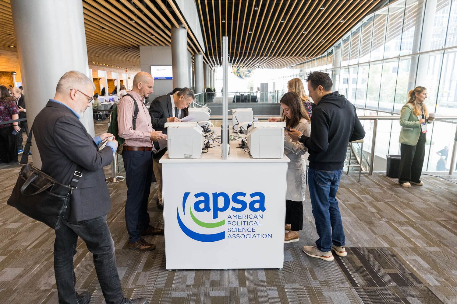 Attendees register at the APSA American Political Science Association conference booth at the Vancouver Convention Centre.