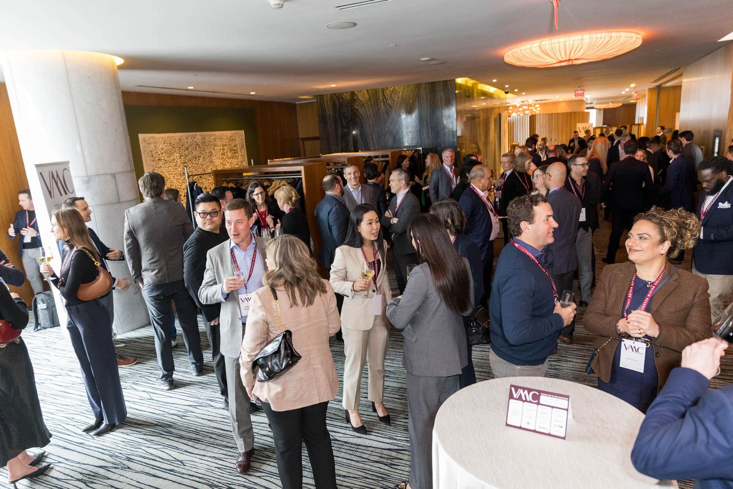 Professionals networking at a corporate conference event in a modern hotel lobby venue.
