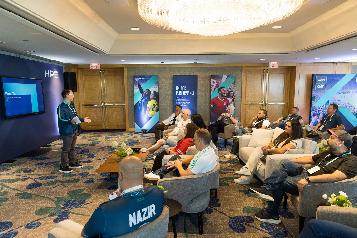 Professionals attend an HPS corporate presentation in a modern hotel conference room with branded banners.