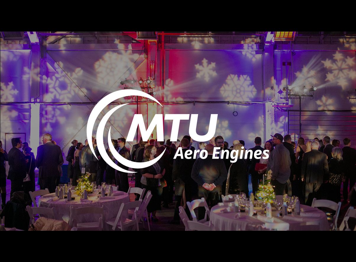 MTU Aero Engines corporate event with elegant round tables, purple lighting, and snowflake projections in a grand venue.
