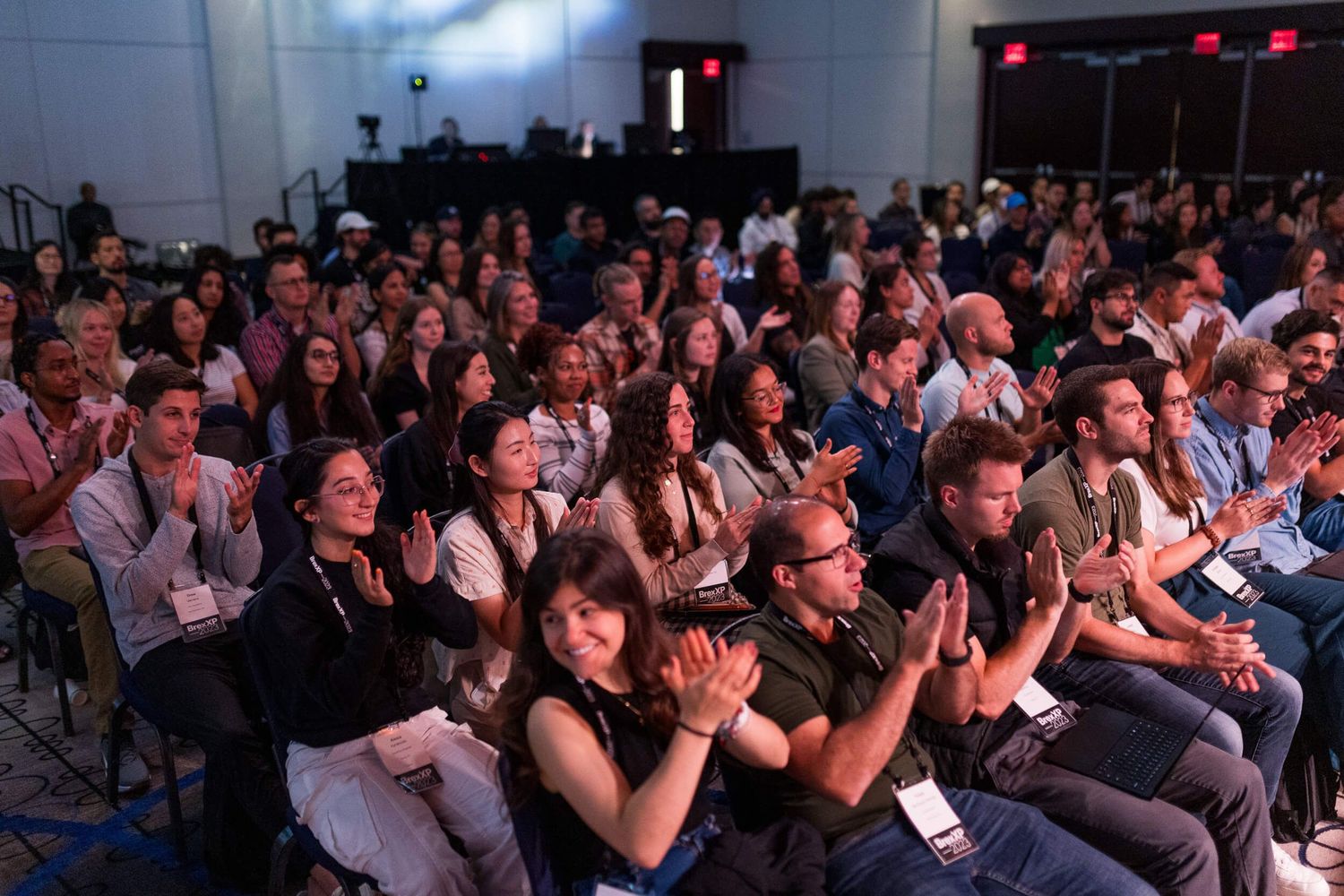 Large audience applauding at an indoor conference or seminar event with rows of seated attendees for BrexXP 2023 conference.