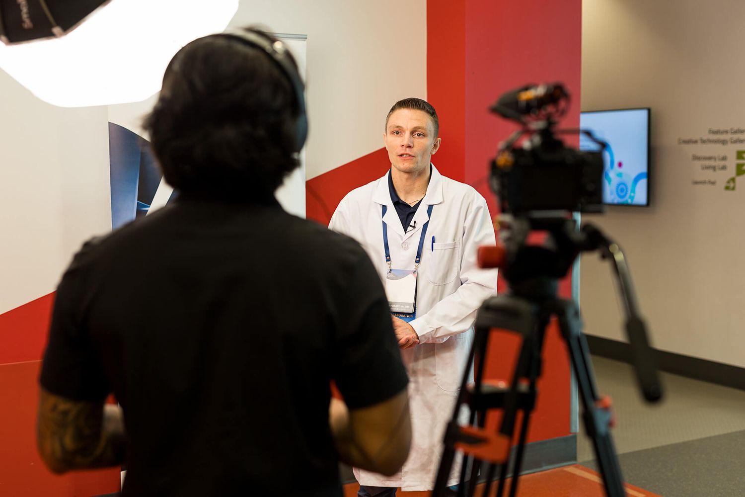 Medical professional in white coat being filmed by videographer at Science World Vancouver