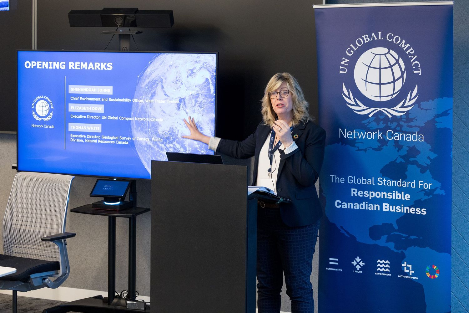 Woman presenting Opening Remarks at UN Global Compact Network Canada responsible business event beside a screen.