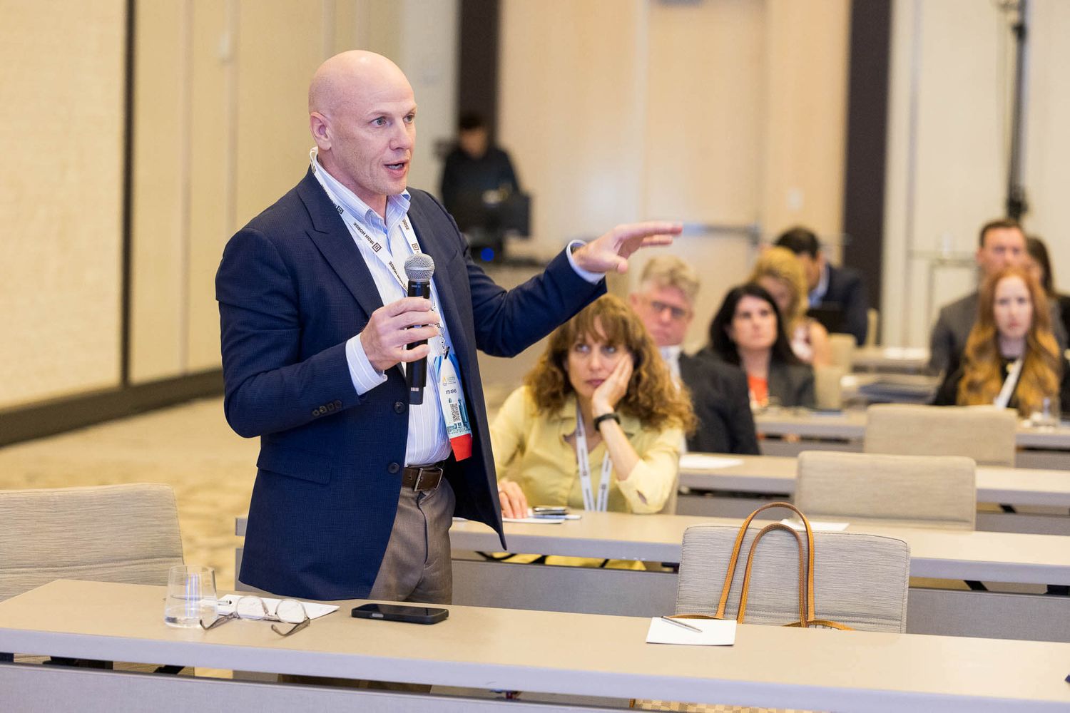 Male speaker addresses audience with microphone at business conference event at the JW Marriott Parq Vancouver.