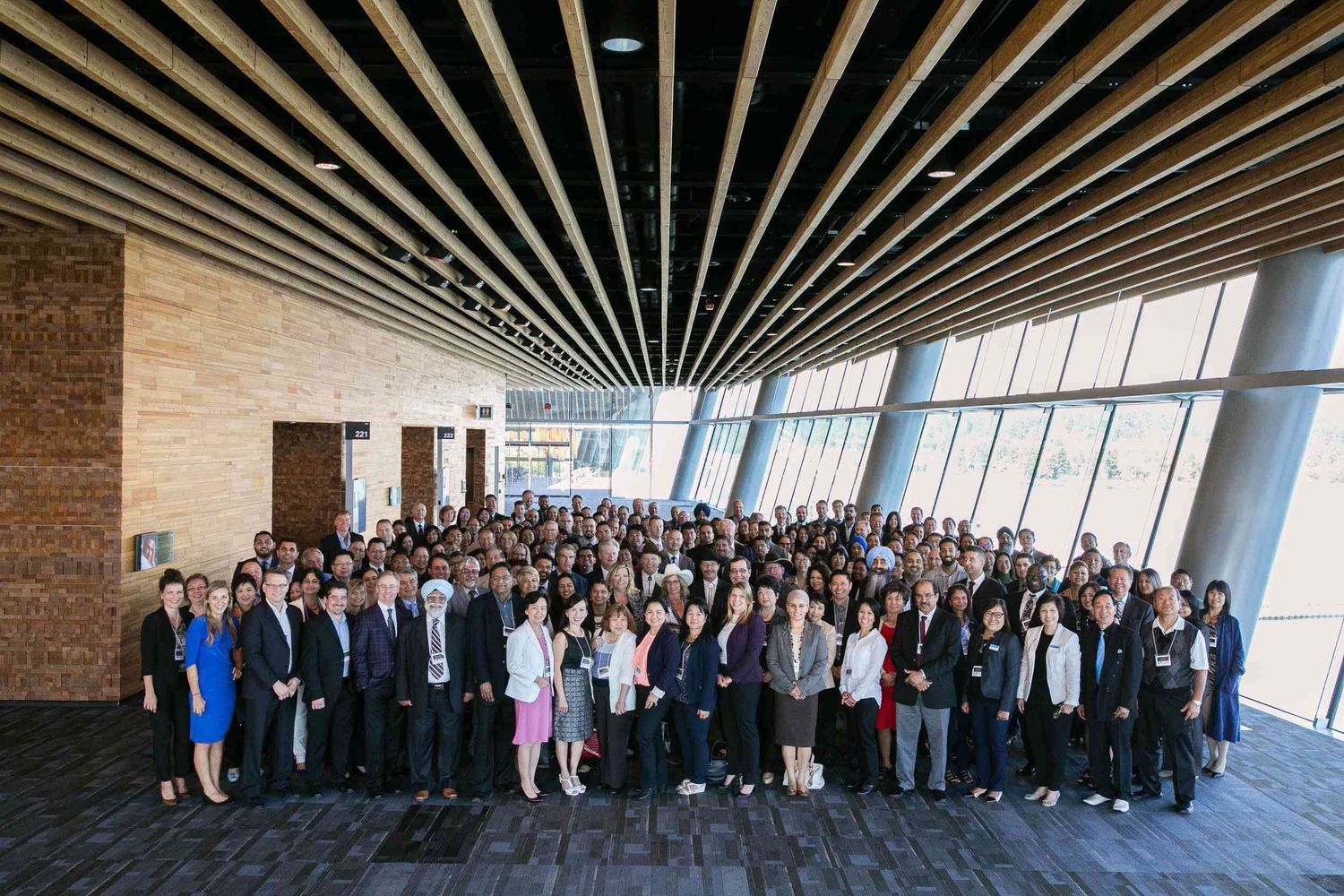 Large group of professional conference attendees pose for a group photo at the Vancouver Convention Centre.