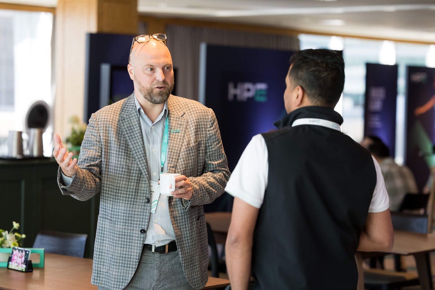 Two business professionals engaged in conversation at an HPE corporate networking event.