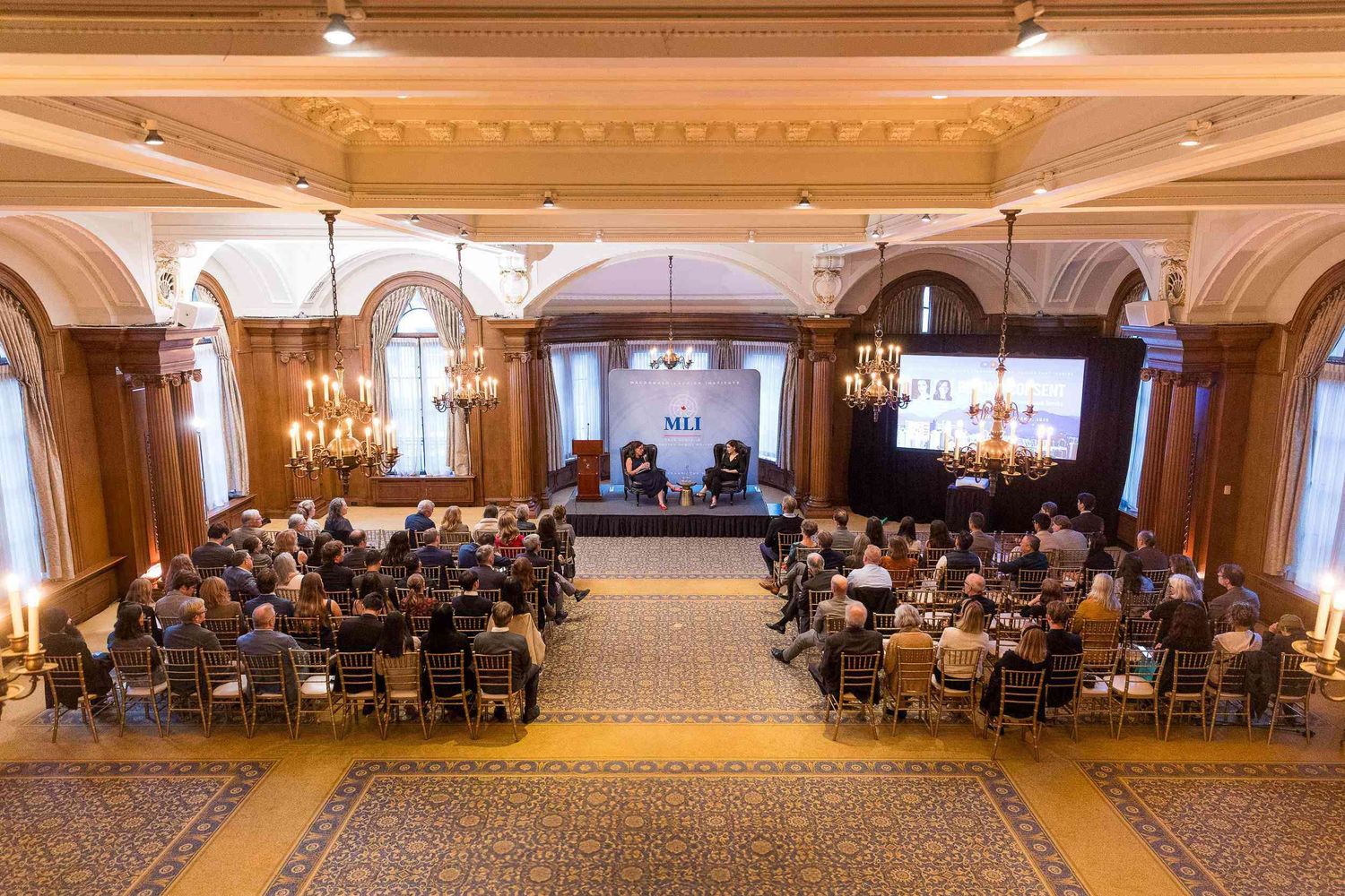 Aerial view of attendees seated in a luxurious ballroom during a professional conference presentation held at the Vancouver Club.