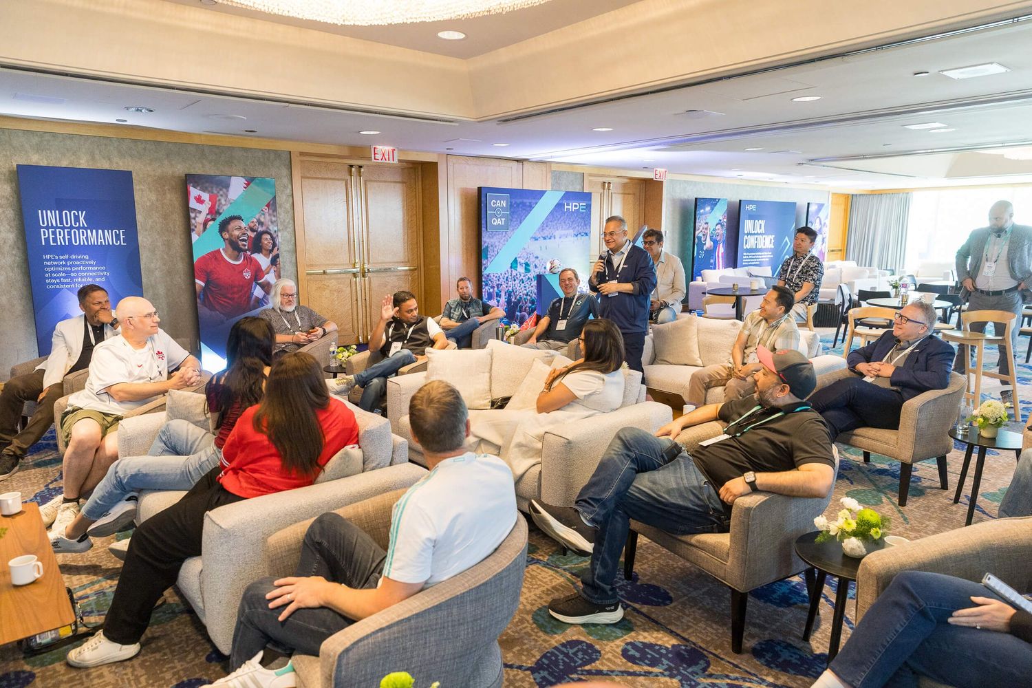 Business professionals gathered in a modern conference room for a corporate seminar with an Unlock Performance banner.