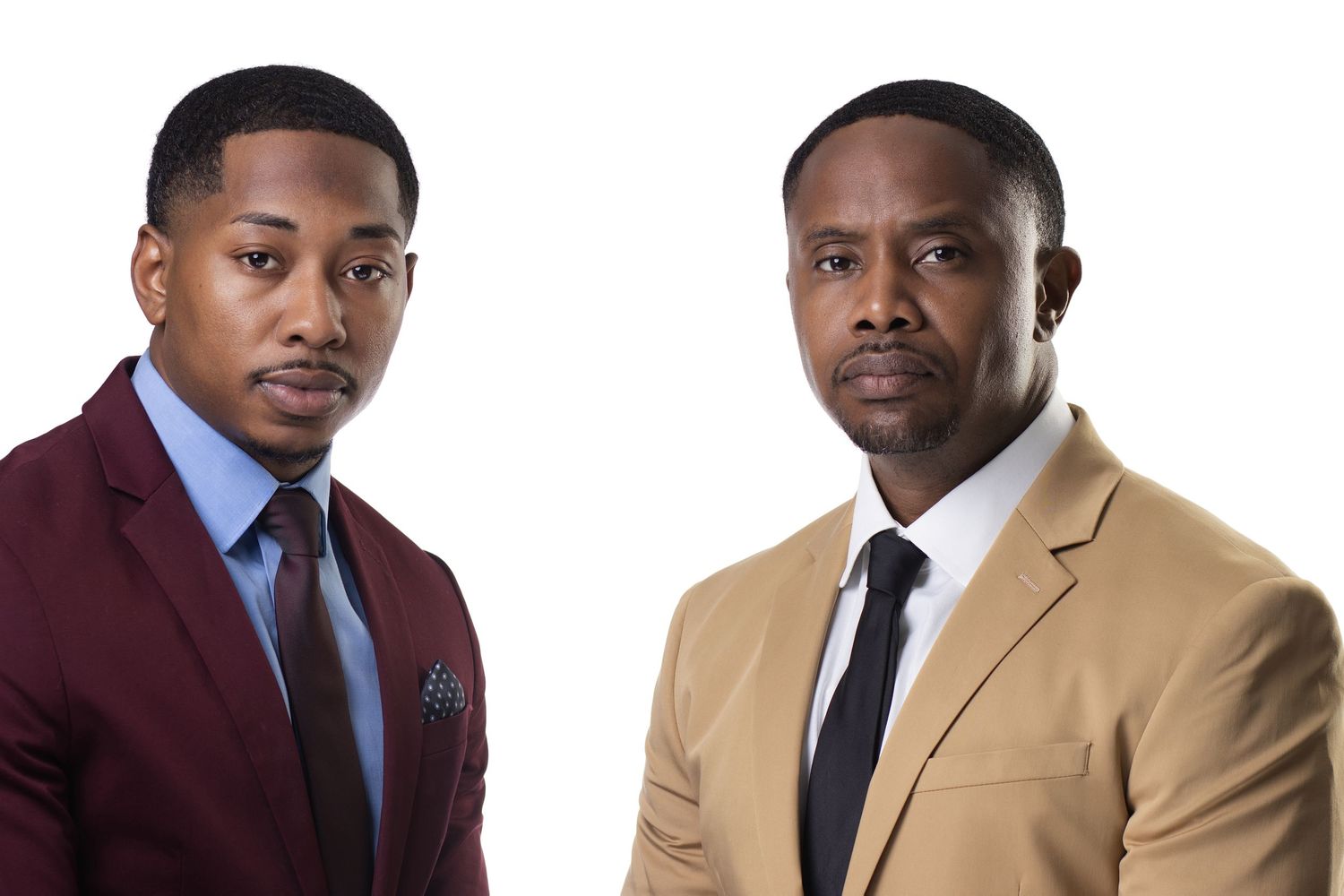 Two well-dressed men in suits posing together against a white background, wearing formal attire with ties.