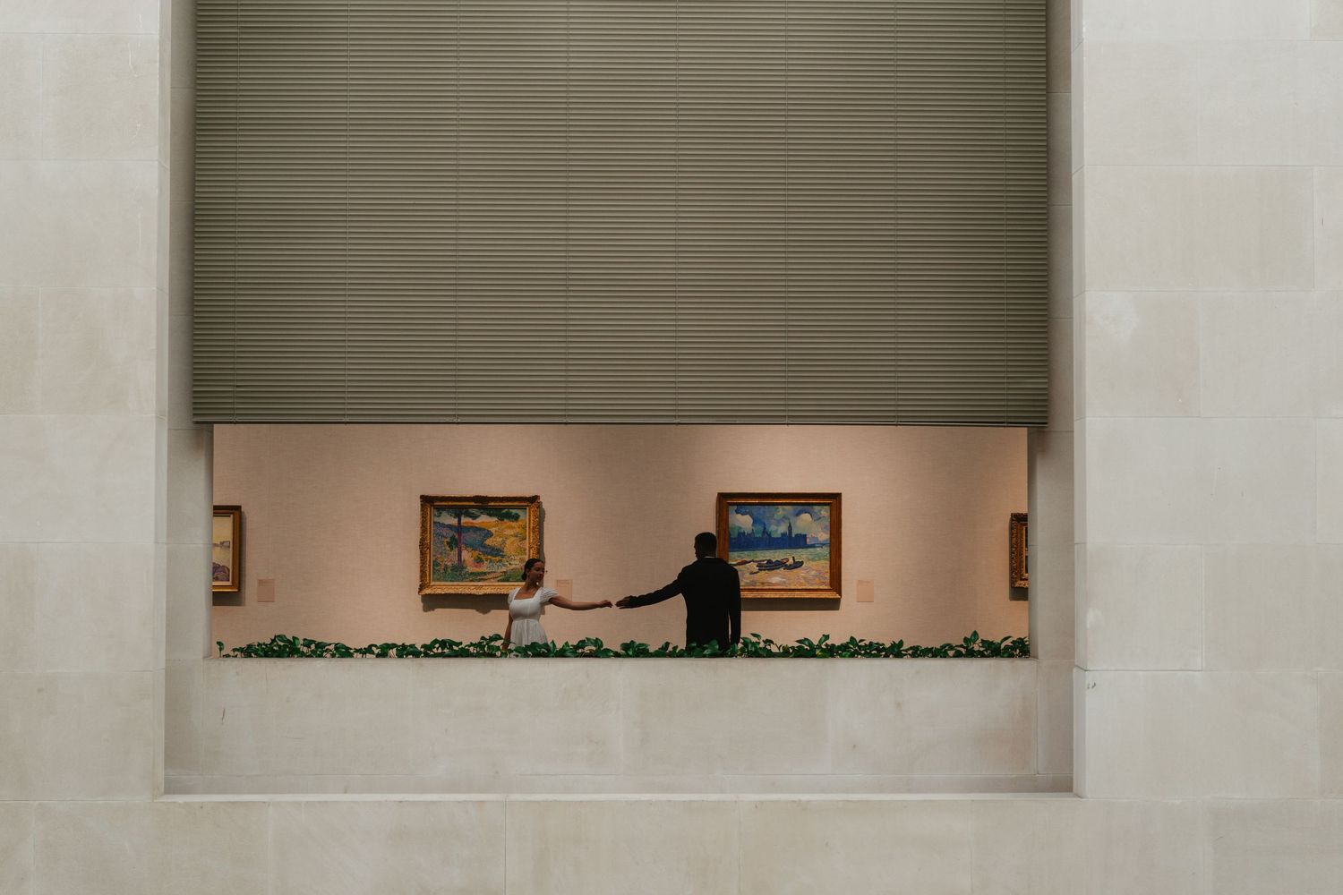 An aerial view of a couple dancing near a fountain surrounded by potted plants on a brick patio.