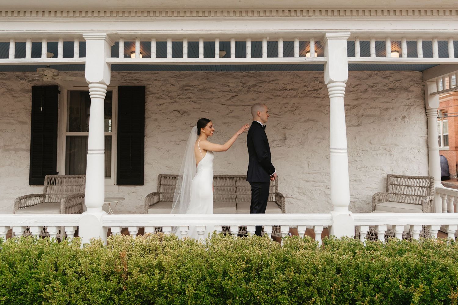 Elegant white columned porch of a wedding venue with stone architecture.