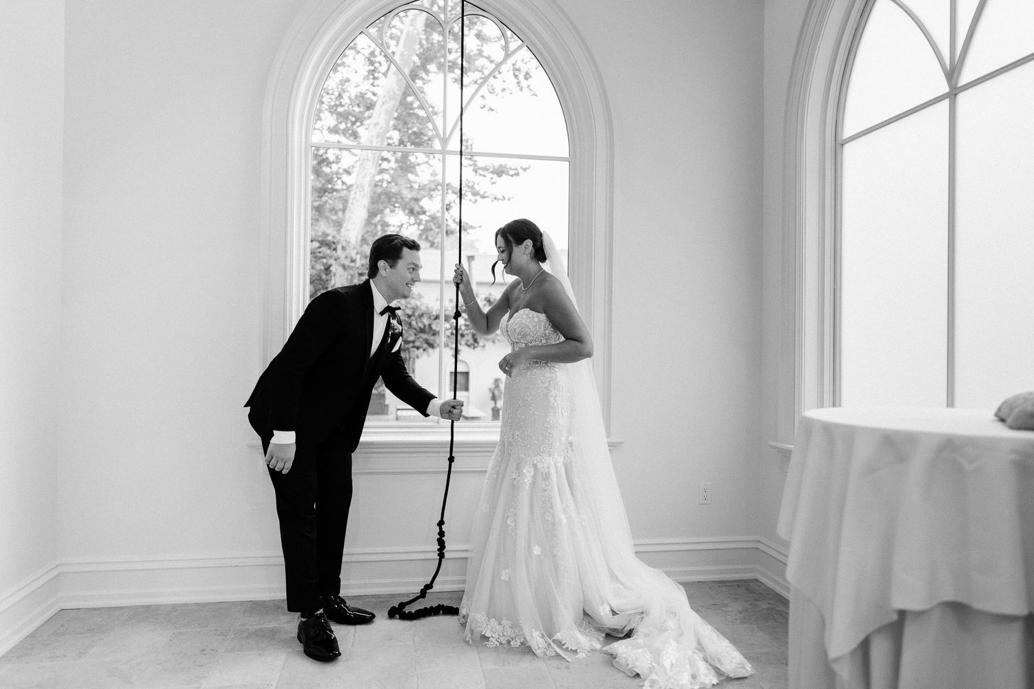 Elegant white room with arched windows and natural light streaming in.