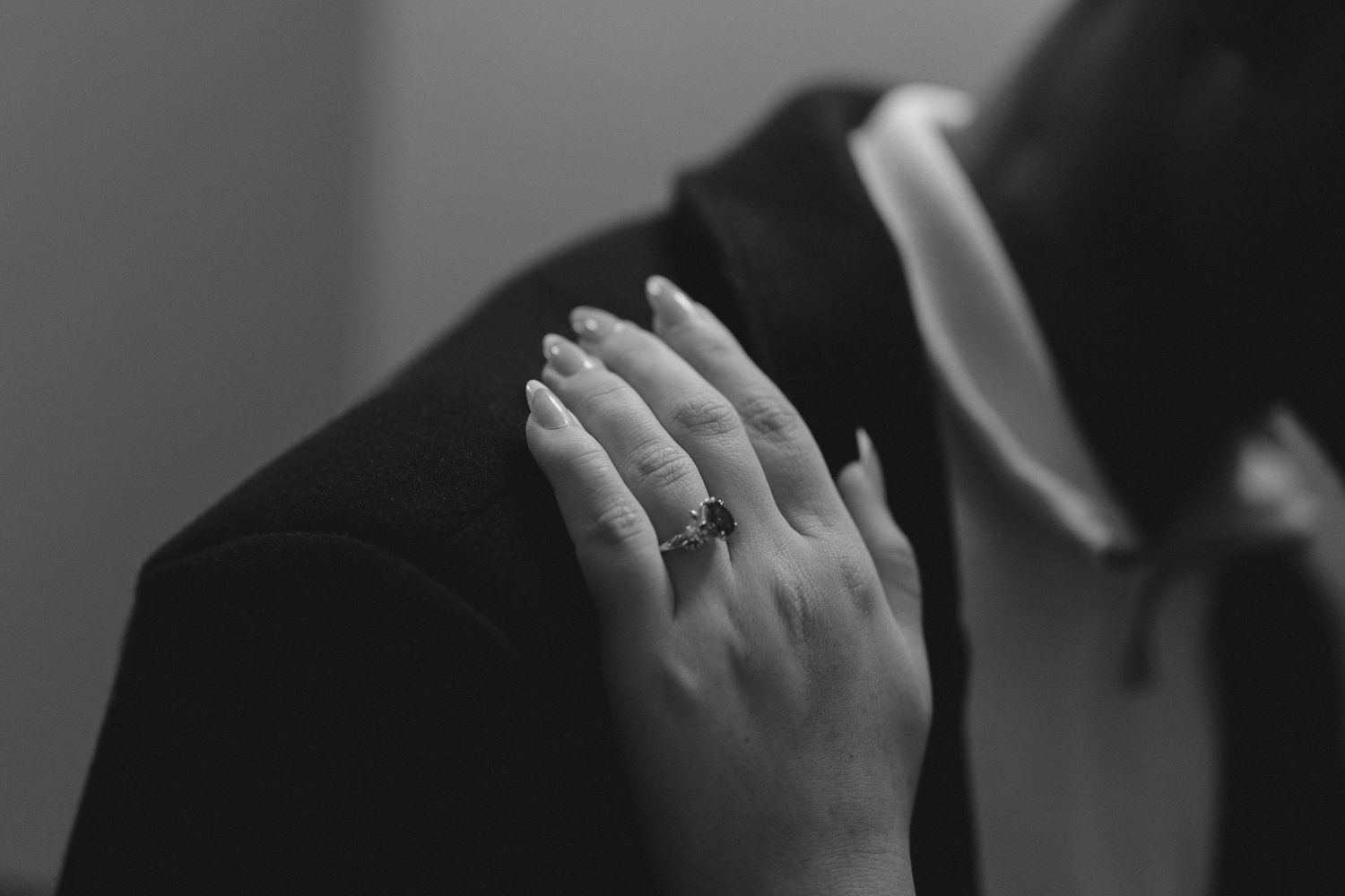 Close-up of hands in dramatic black and white lighting.