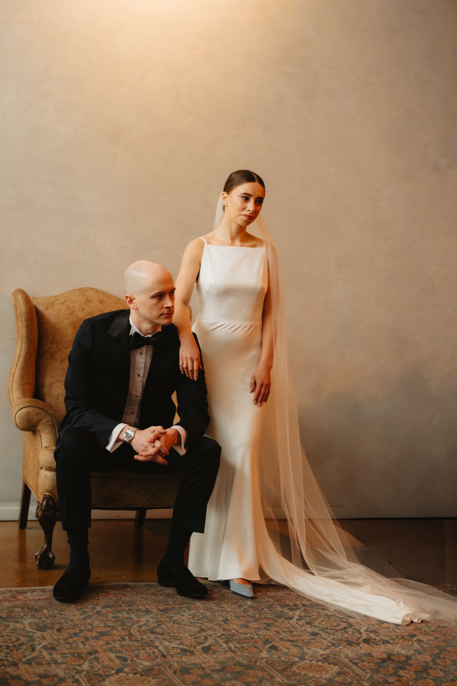 Artistic wedding portrait series showing a couple in formal attire posing against a neutral studio backdrop.