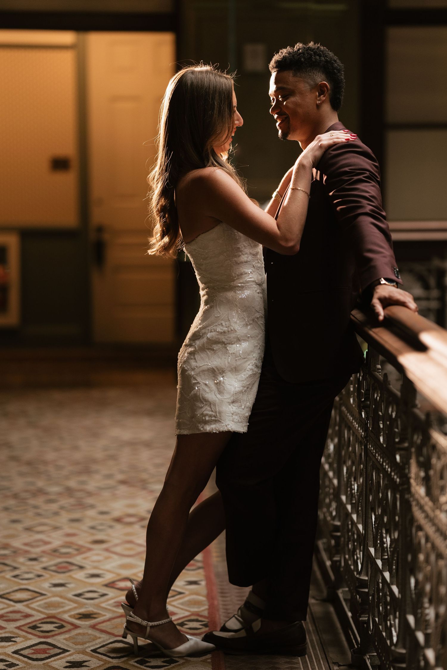 Couple embraces in a romantic dance sequence along a decorative hallway.