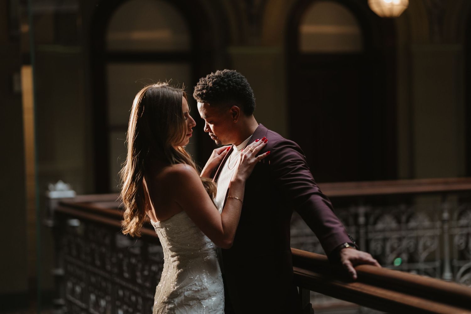 Couple shares a romantic moment in a dimly lit vintage interior space.