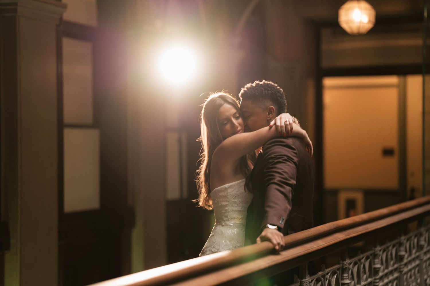 Dramatic silhouettes against warm lighting create a romantic atmosphere in an elegant indoor setting.