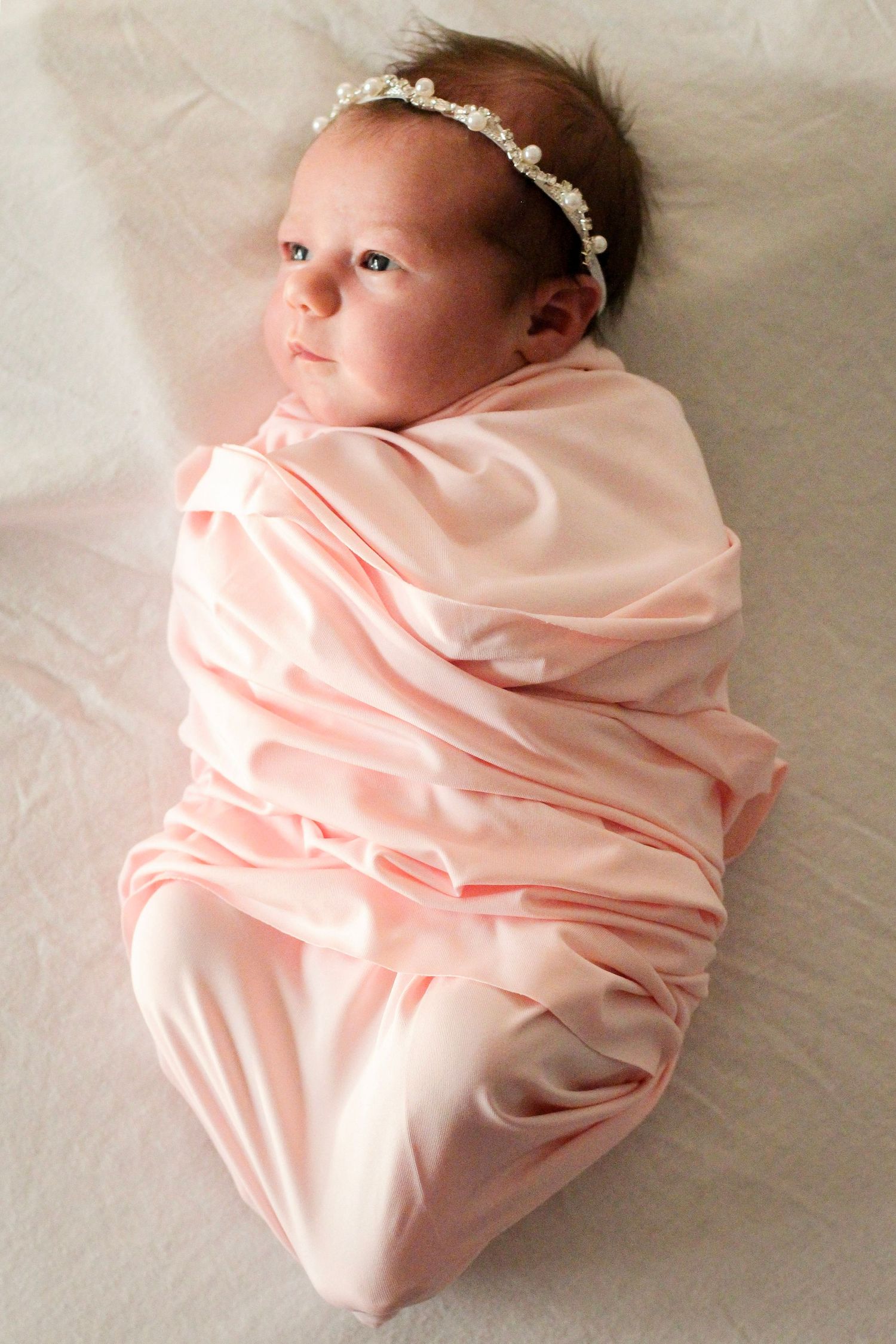 Newborn baby girl in a swaddle during a professional newborn session in Charlotte, NC.
