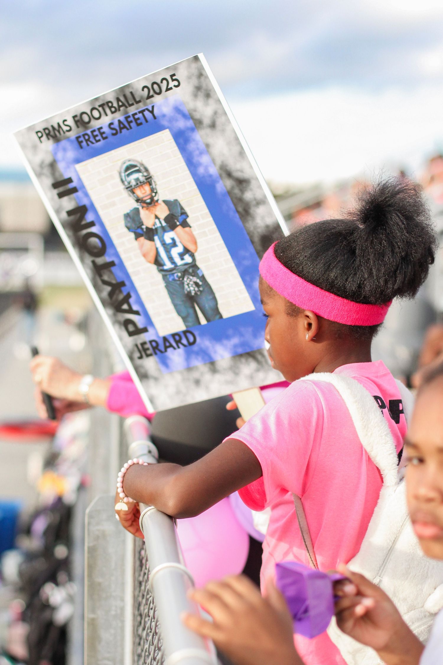 A little sister cheering for her big brother during a football game at Weddington High School.