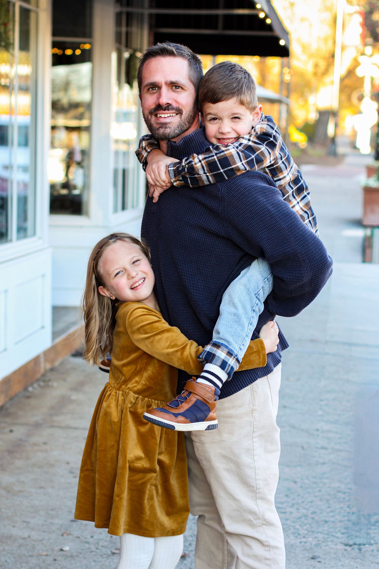 Father giving his son a piggyback ride while walking through downtown Matthews.