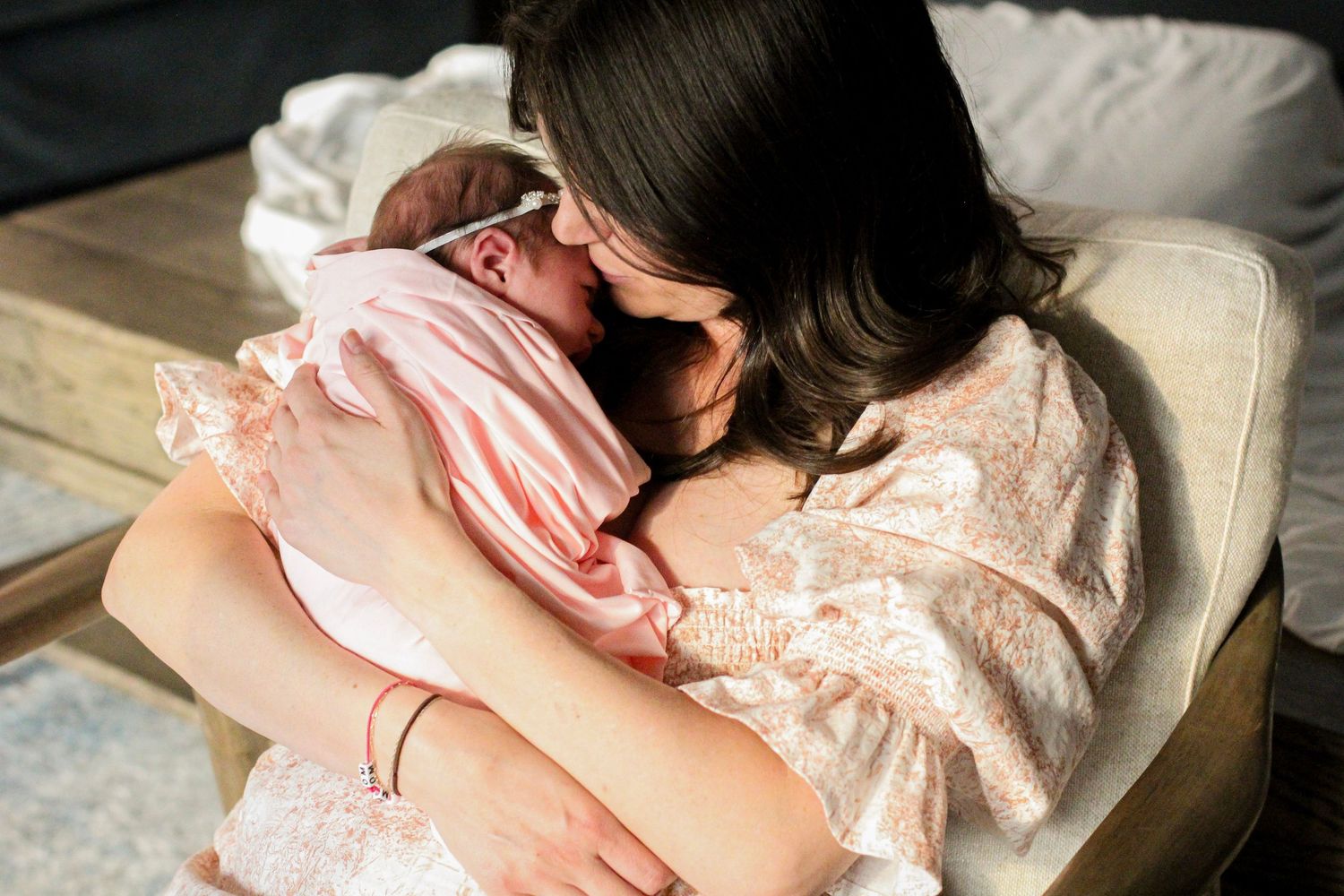 Mom snuggling her new baby during a lifestyle newborn session in Charlotte.