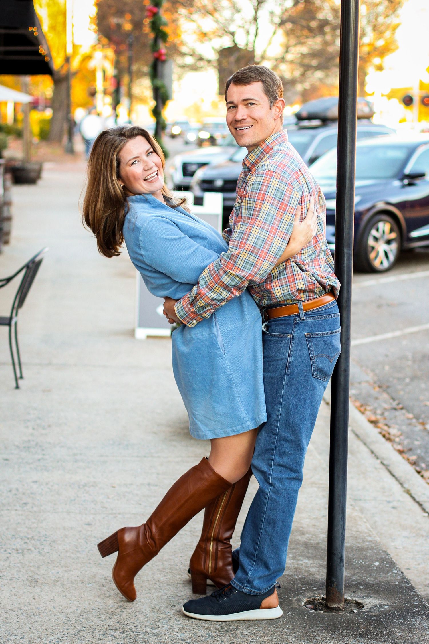 Married couple leaning against a lamppost for portraits in Matthews, NC.