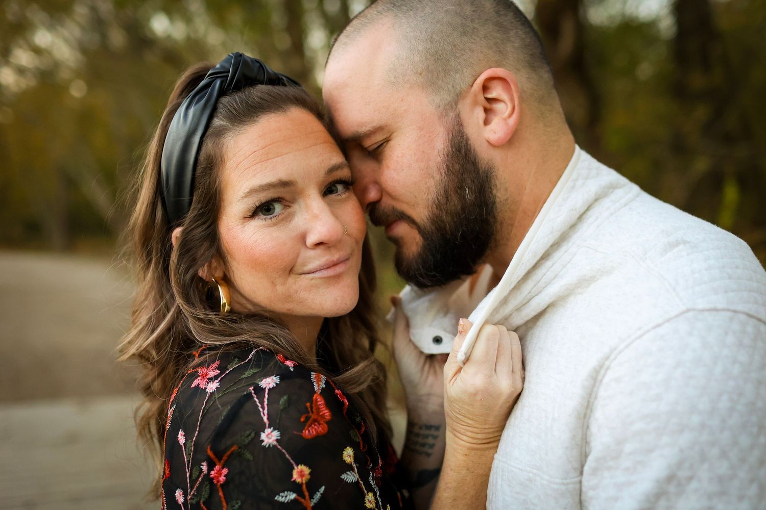Husband and wife sharing an intimate moment during an anniversary session at McAlpine Park.