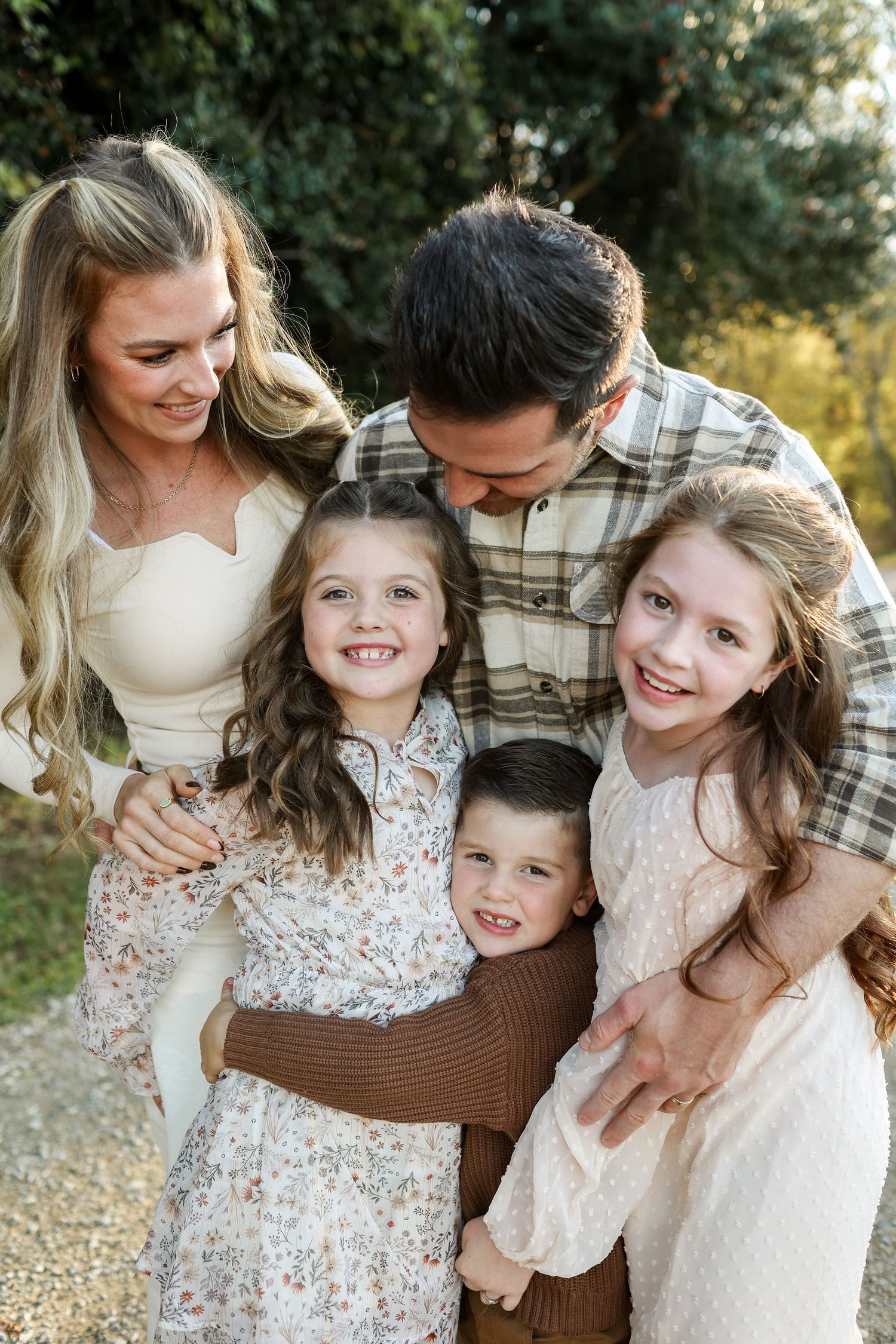 Large family of five laughing during a professional outdoor photo shoot at McAlpine Park.