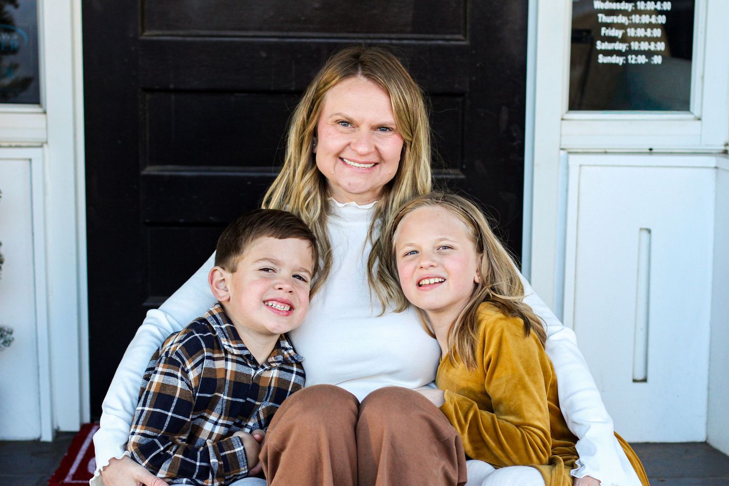 Mother sitting with her children in front of a local shop in downtown Matthews, NC.