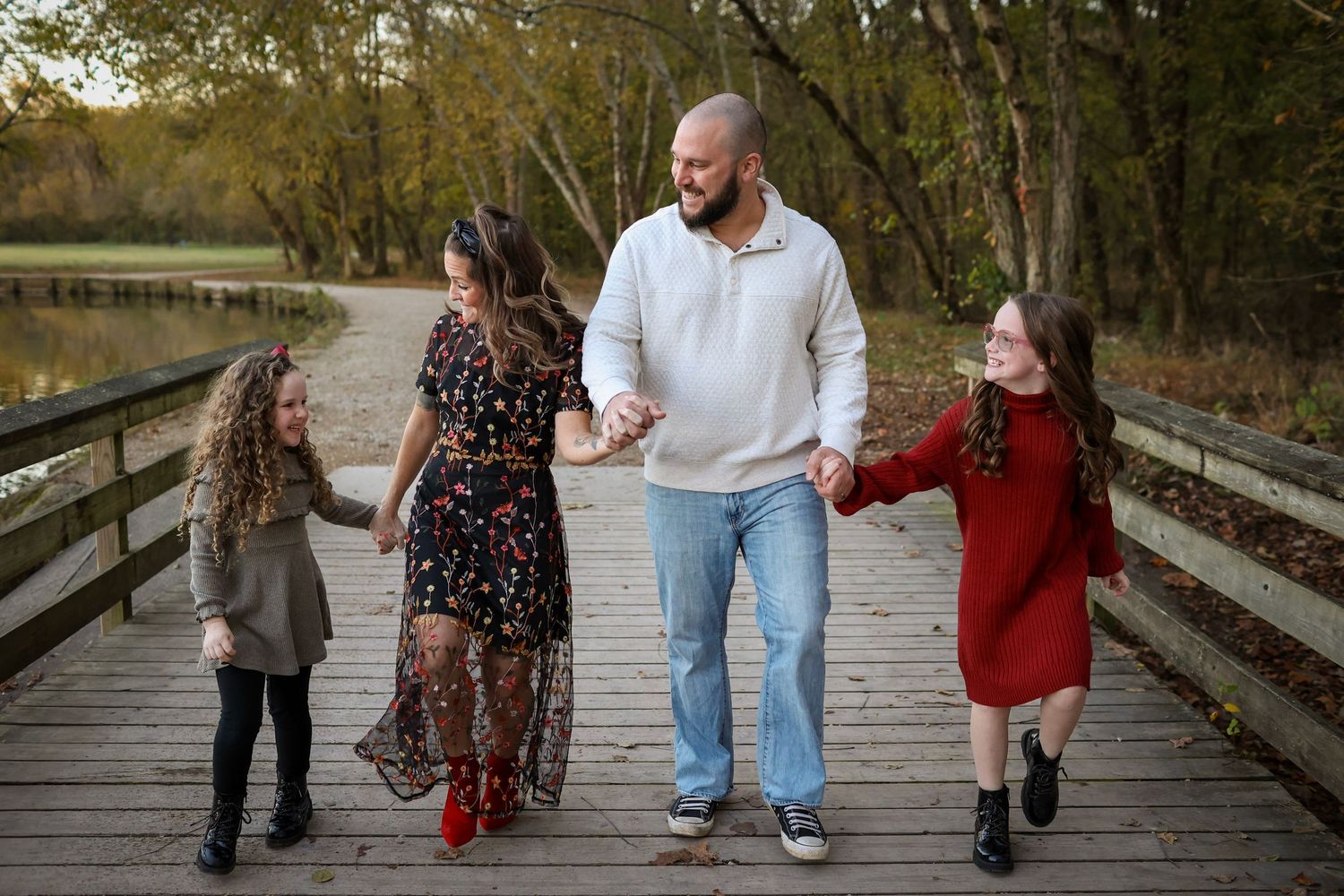 Family of four walking through the trails at McAlpine Creek Park for a family photo session in Charlotte, NC.