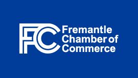 White Fremantle Chamber of Commerce logo on blue background with text and circular emblem design.