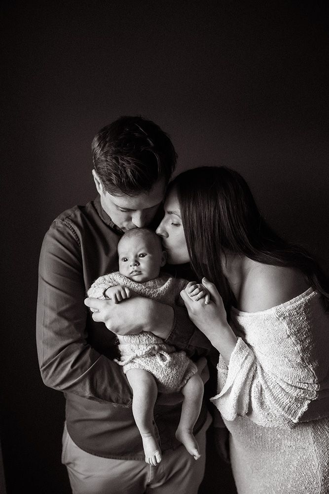 Manchester newborn photographer black & white intimate family portraits showing tender moments between parent and baby in dramatic lighting.