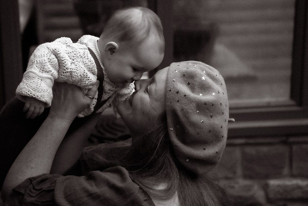 A tender black & white photograph captures a loving moment between a mother and baby embracing, during a motherhood photoshoot in Lancashire