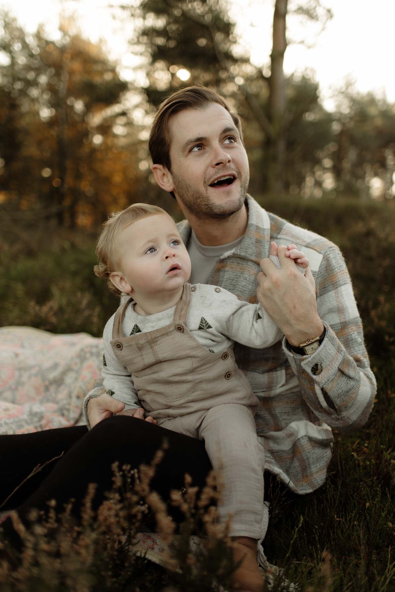Two people enjoy a tender candid moment together outdoors during golden hour in autumn.
