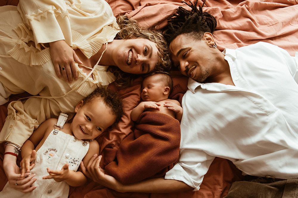 Newborn photography in Manchester. Heartwarming photo showing a couple sharing intimate and playful moments while lying down together.