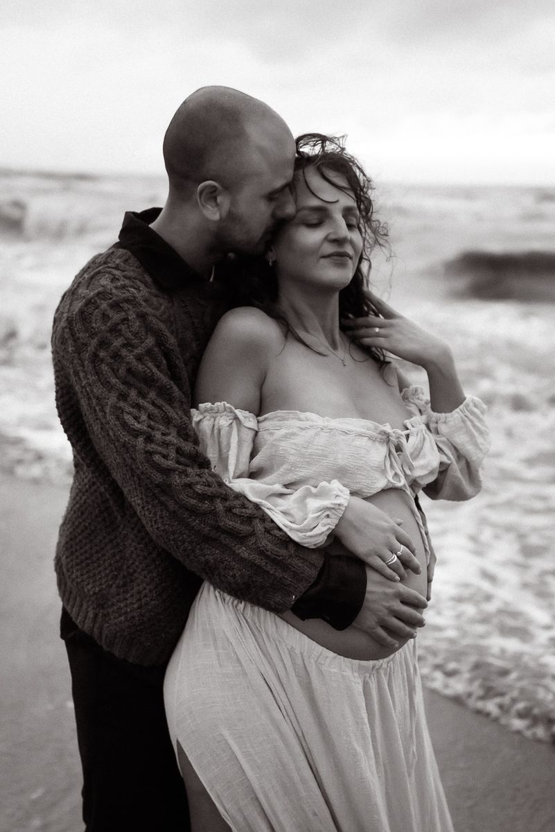 Maternity photographer Lancashire. A romantic black and white beach photo showing an intimate embrace between a couple by the ocean waves.