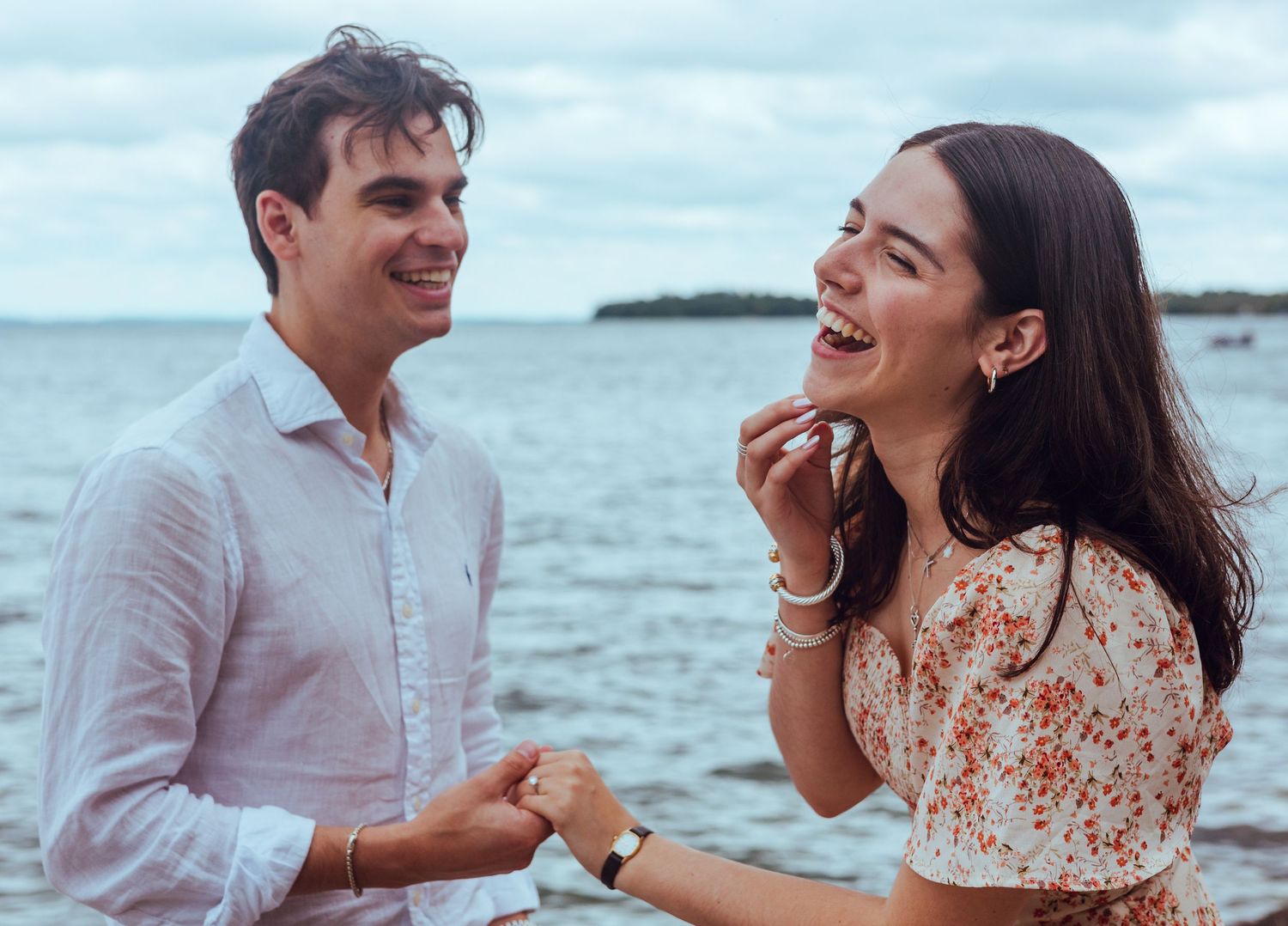 Couple sharing a joyful moment together by the ocean at sunset.