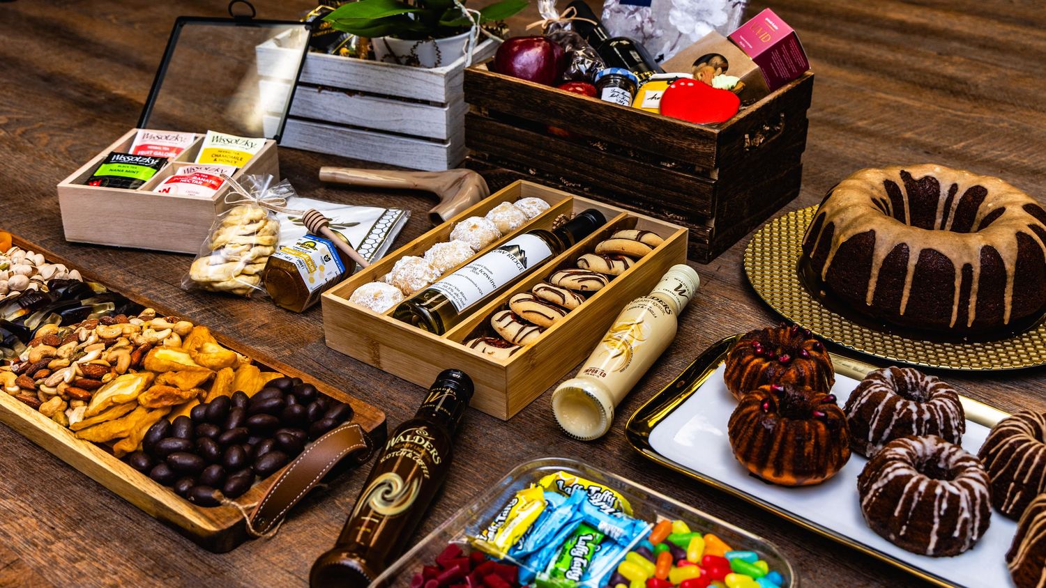 Assorted chocolate desserts, candies, and baked treats arranged on wooden serving platters at a dessert buffet table.