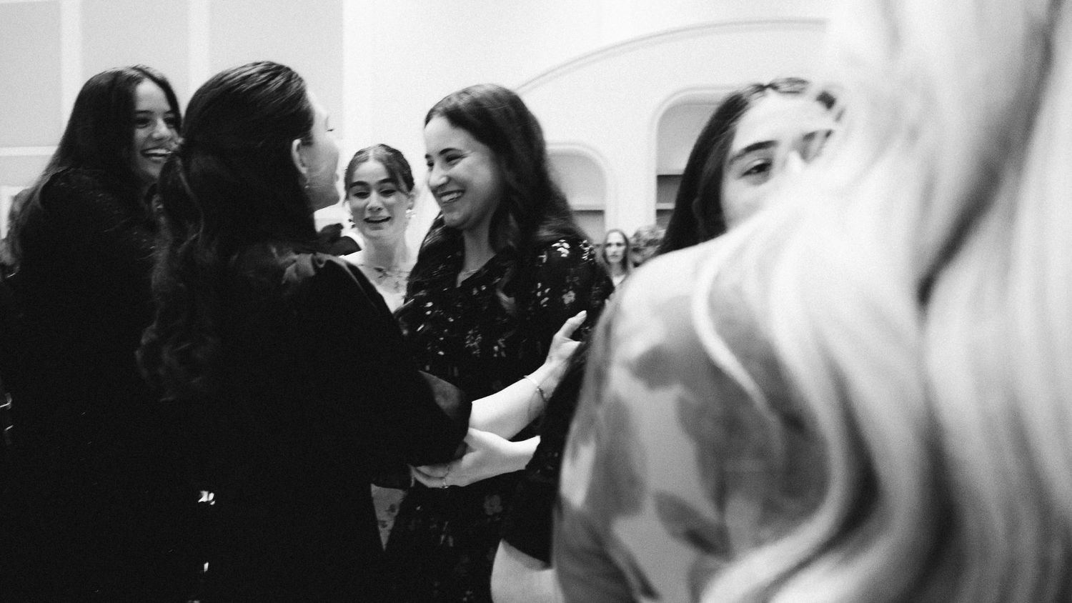 Group engaged in animated conversation in a black and white candid moment.
