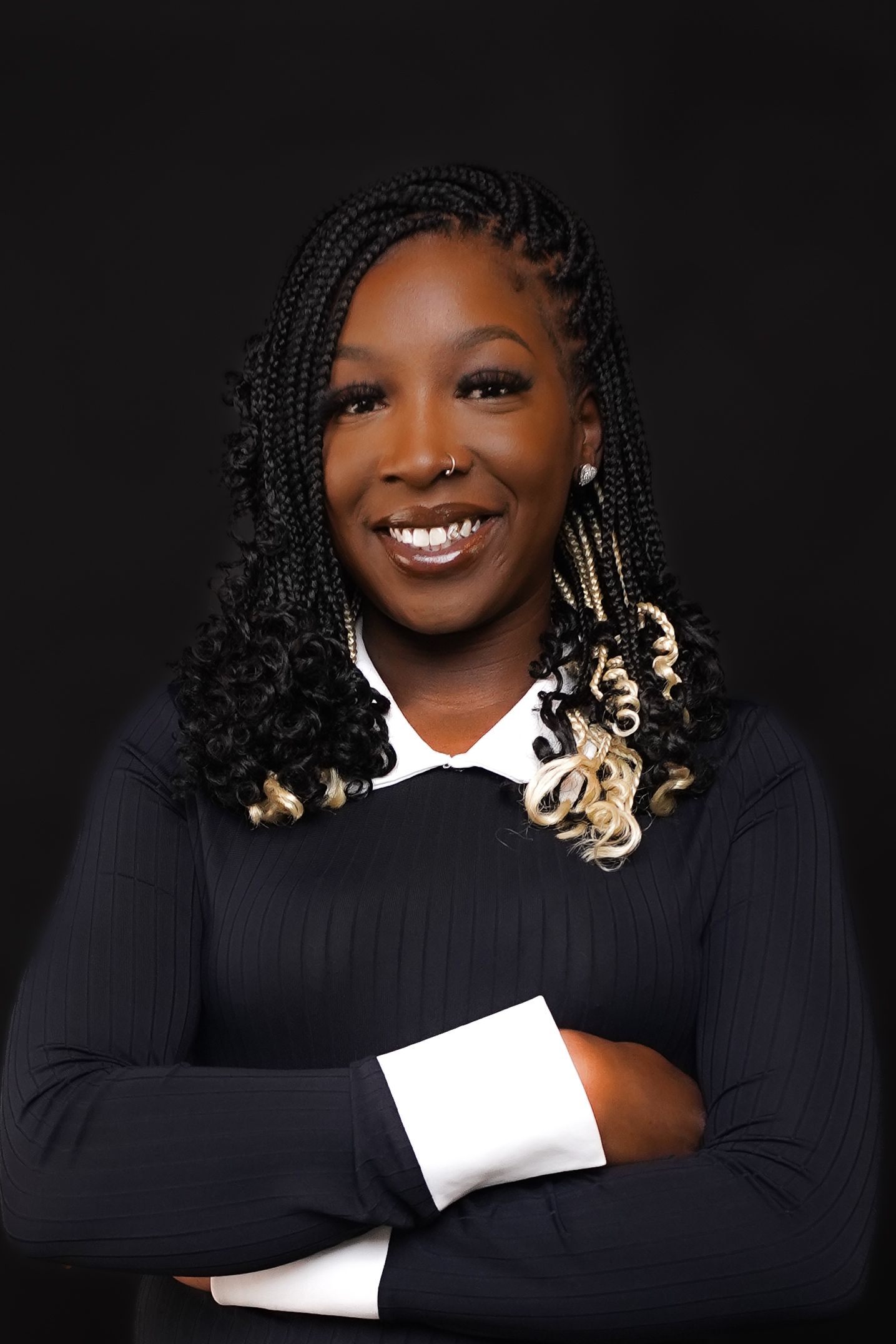 Professional portrait of person in black blazer against rustic wooden wall background.