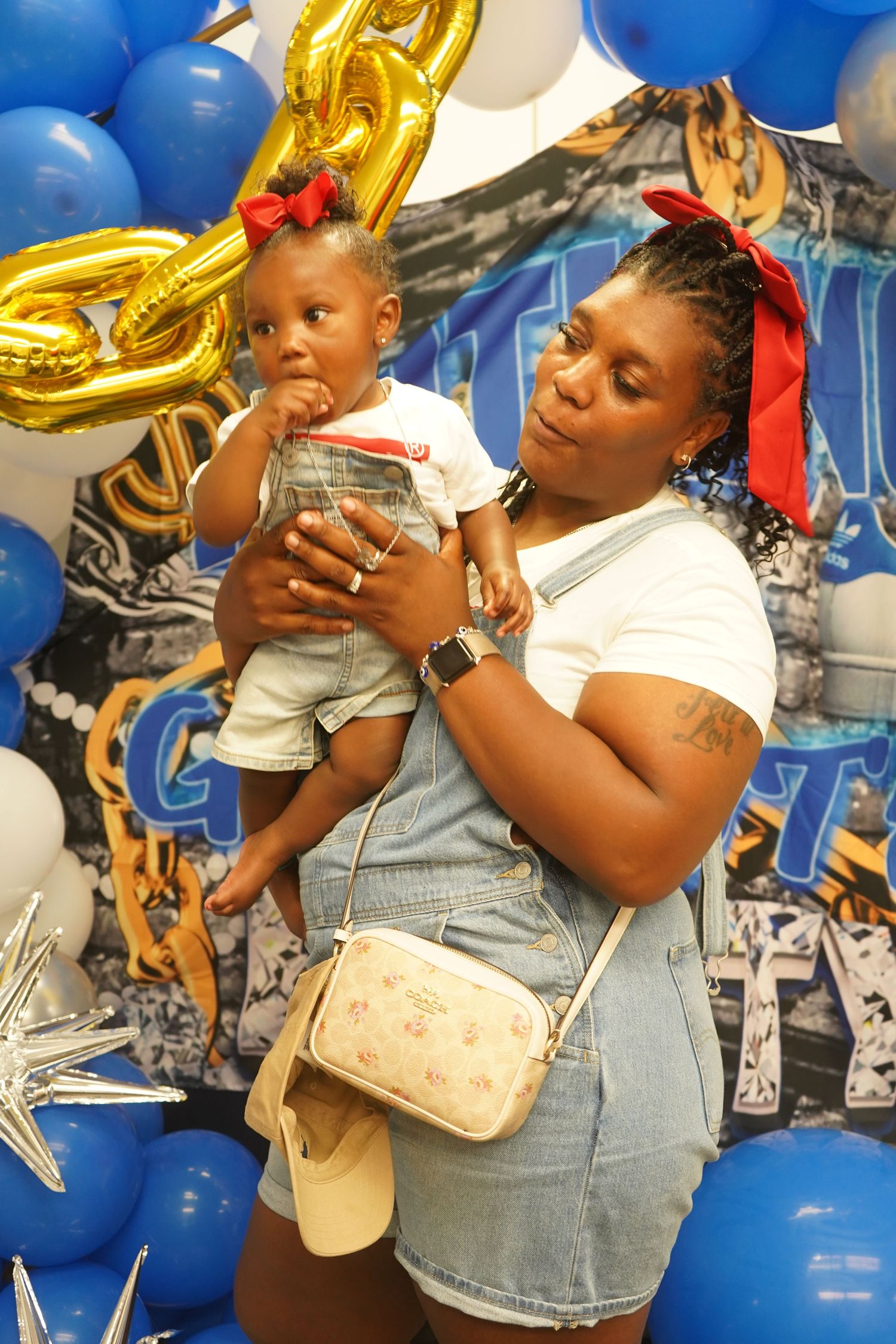 A celebratory scene with gold balloons and blue decorations at what appears to be a birthday party or special event.