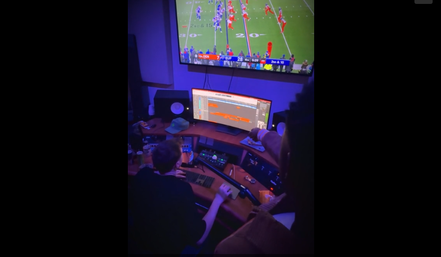 Multiple screens display live sports match analysis with tactical overlays and statistical data in a dark control room setting.