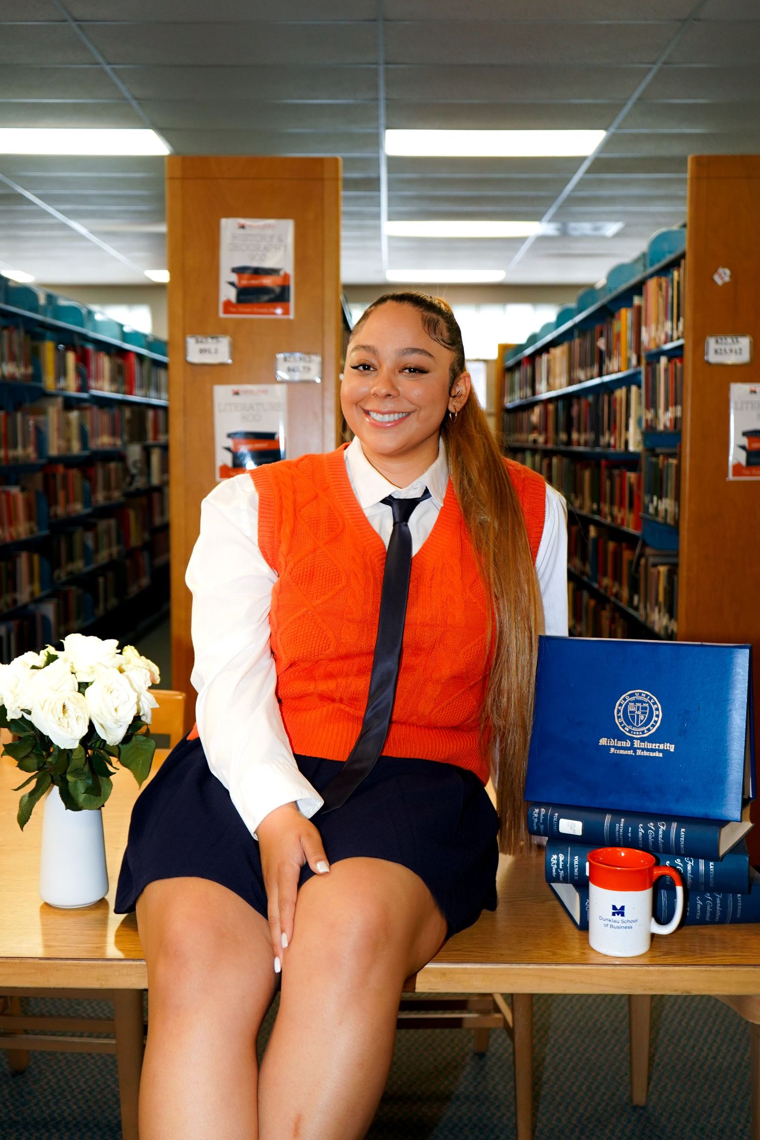 A photo series in a library showing orange and white academic attire against bookshelves.