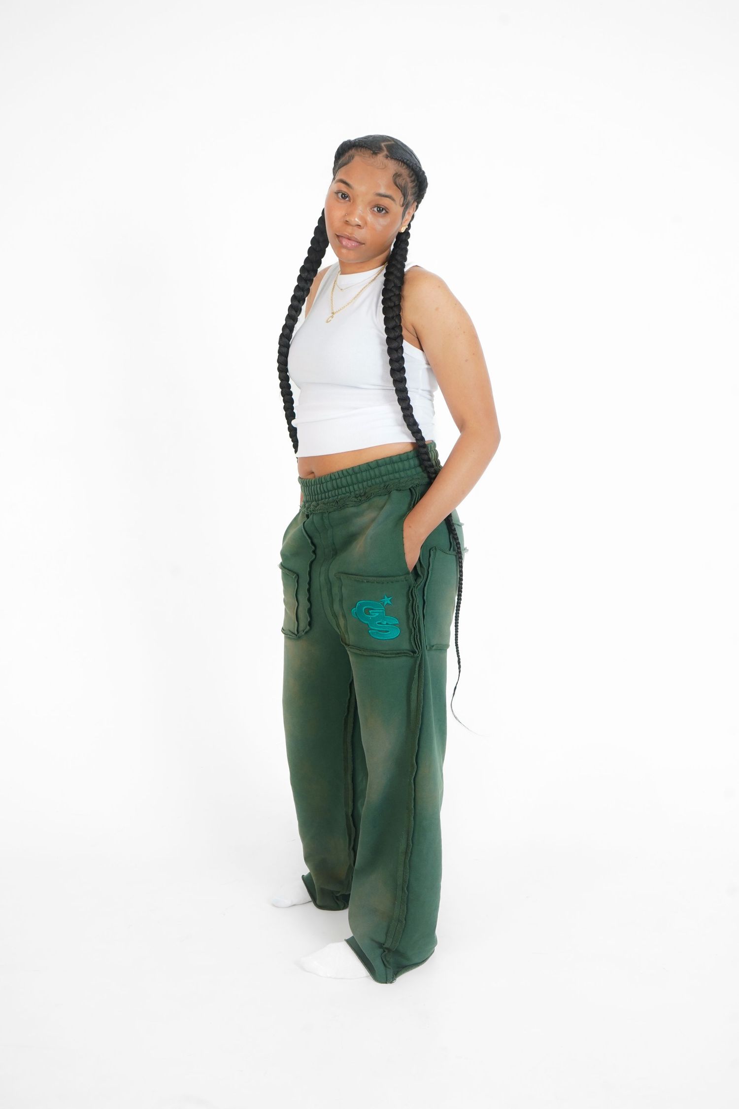 Person wearing white crop top and green cargo pants poses in multiple angles against white background.
