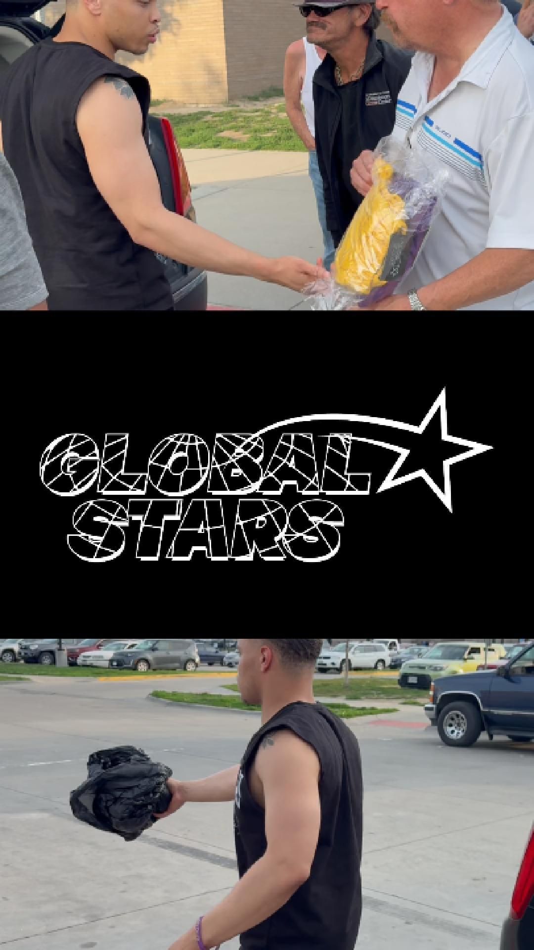 People exchanging snacks in a parking lot while standing near cars.