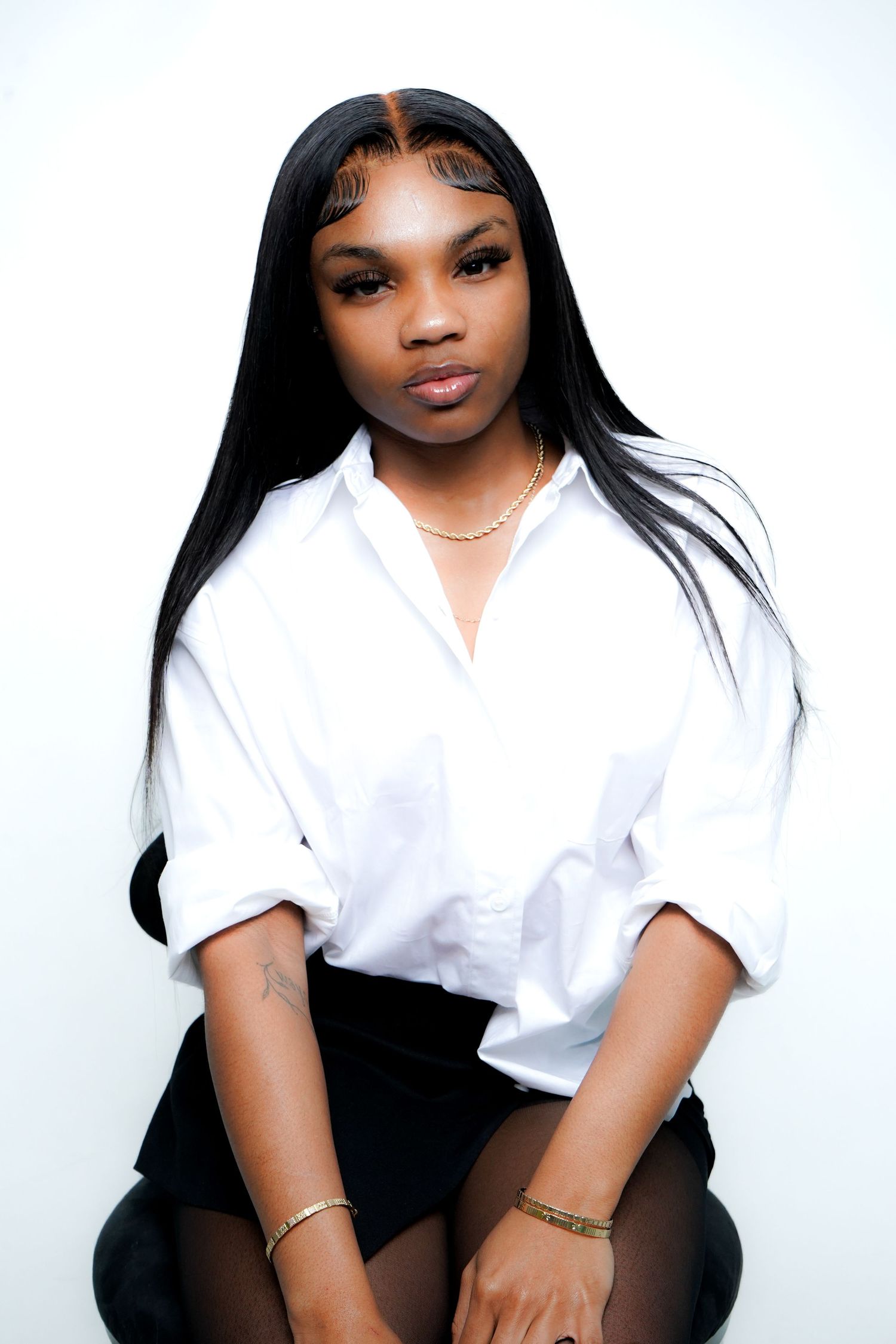 Professional studio portraits in classic white button-down shirt and dark bottoms against white background.