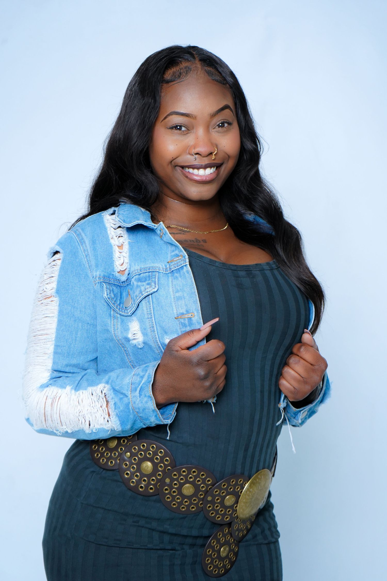 Fashion portraits showing distressed denim jacket and dark top against white studio background.