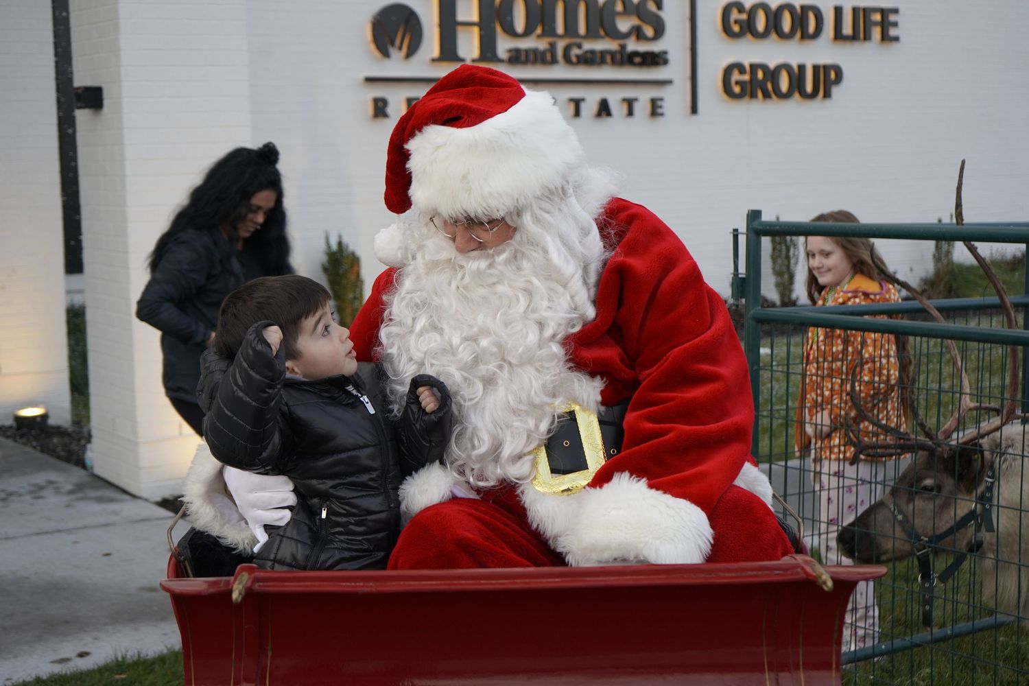 Santa Claus visits with families at a holiday event featuring multiple photo opportunities.