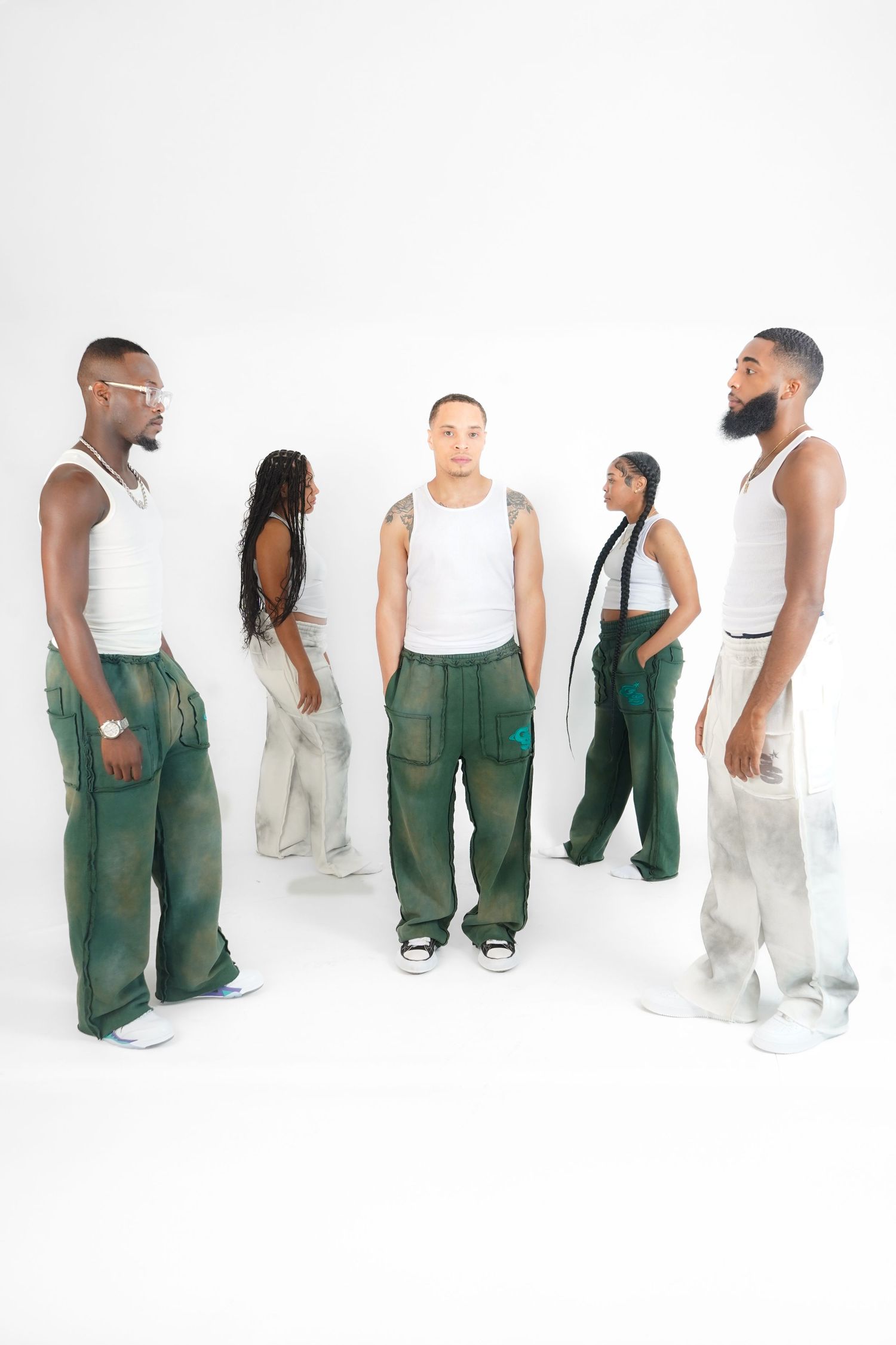 Models in white and green overalls pose in artistic fashion lookbook series.