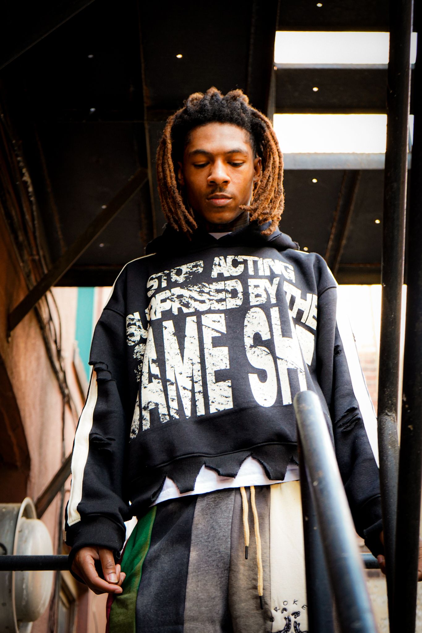 A person wearing a black and white graphic t-shirt with text is photographed in a series of cropped shots.
